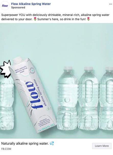 A carton of Flow alkaline spring water is displayed next to three clear plastic water bottles on a light blue background.