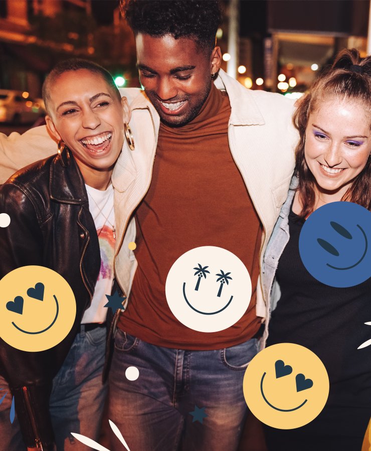 Three friends stand close together, smiling and laughing at night on a city street, with illustrated smiley faces and shapes overlaid on the photo.