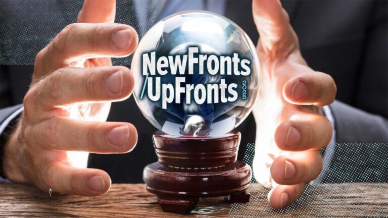 A person holds a crystal ball with the words "NewFronts UpFronts" inside, resting on a wooden surface.
