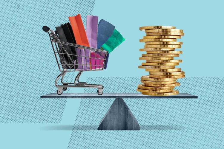 A shopping cart with colorful bags and a stack of gold coins are balanced on a seesaw against a blue background.