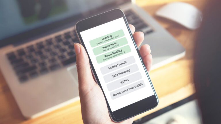 A person holds a smartphone displaying a website performance checklist with items like loading, interactivity, mobile friendly, safe browsing, and HTTPS.
